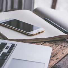 91免费看产品负责人何一舟在笔记本与手机之间比对页面加载速度，桌面摆着便签草稿